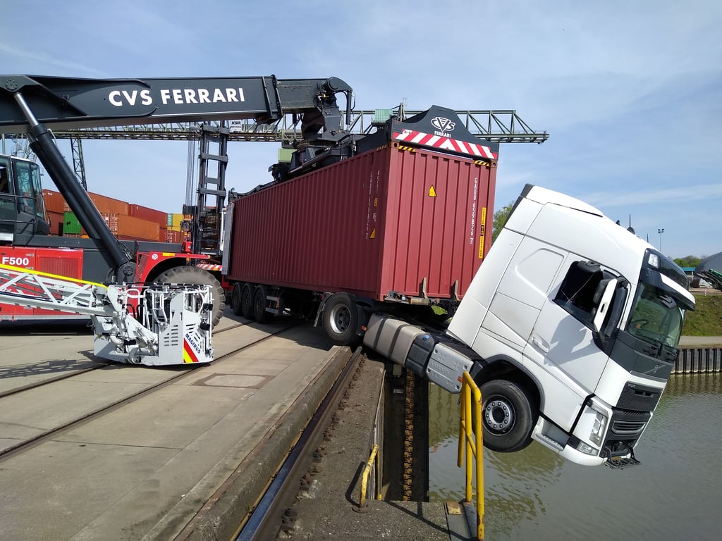 Das Fahrerhaus eines Lkw ragt nach einem Unfall über ein Hafenbecken. Die Feuerwehr konnte das Fahrzeug sichern und den Fahrer retten.