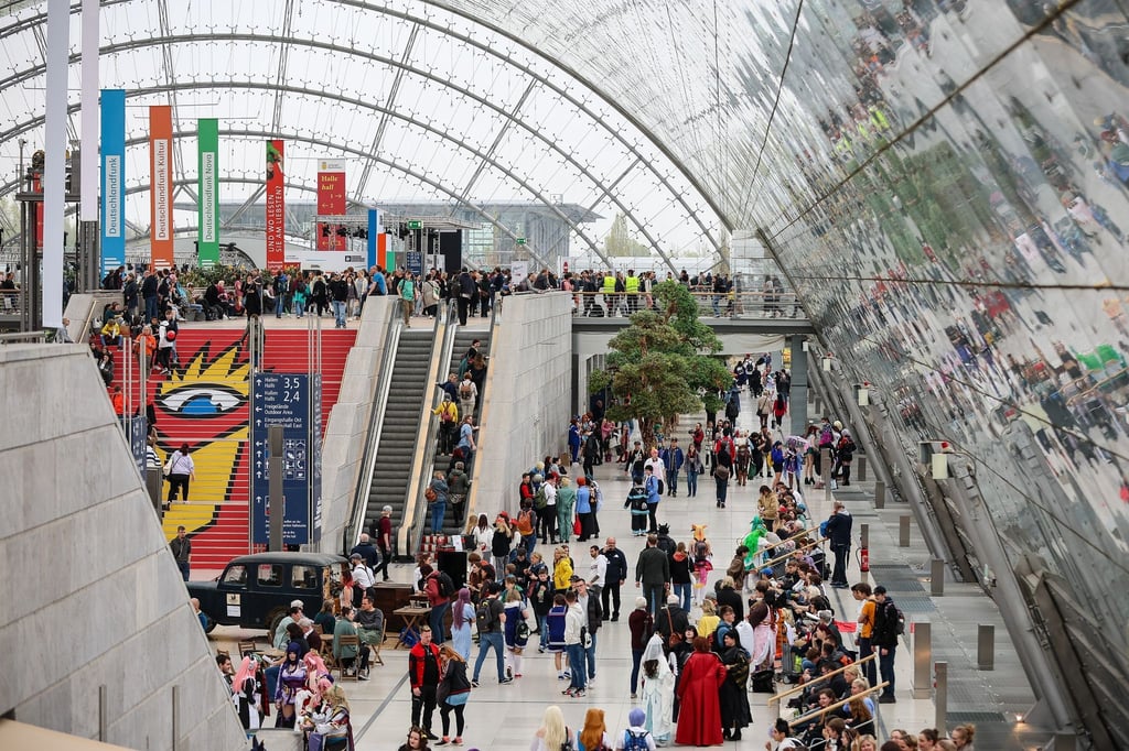 Besucherinnen und Besucher gehen am zweiten Messetag durch die Glashalle der Leipziger Buchmesse.