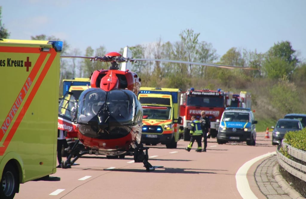 Einsatzfahrzeuge und ein Rettungshubschrauber stehen an der Unfallstelle auf der A38 bei Querfurt.
