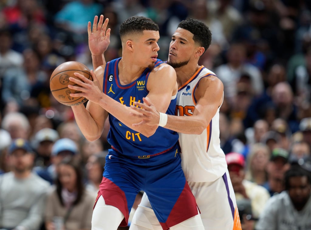 Nuggets-Forward Michael Porter Jr. (l) schirmt den Ball gegen Suns-Star Devin Booker ab.