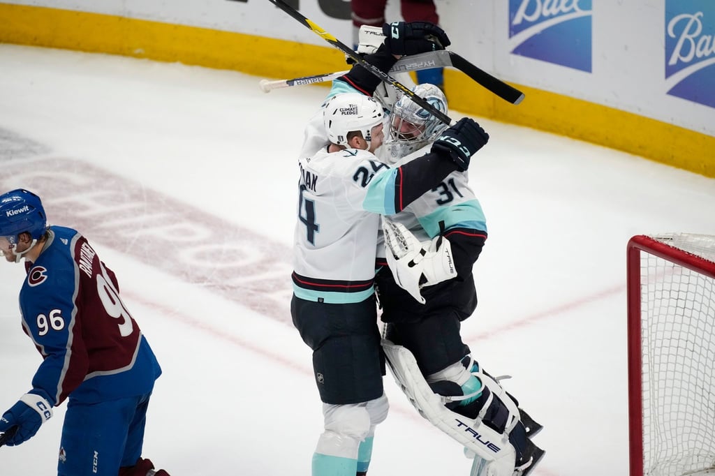 Kraken-Torwart Philipp Grubauer (r) jubelt nach der Schlusssirene mit Mitspieler Jamie Oleksiak.