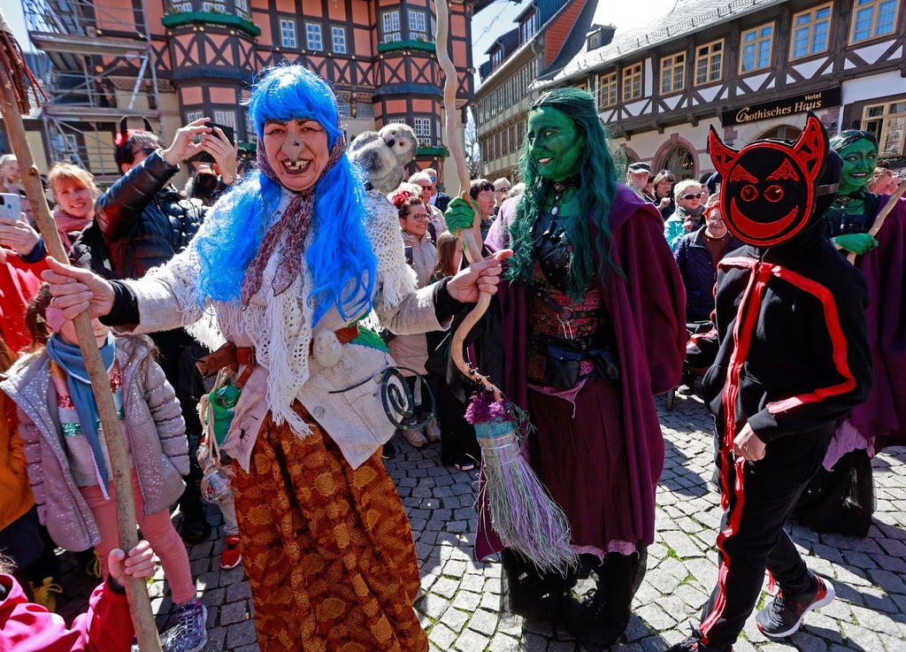 Walpurgisbesucher in Wernigerode tanzen vor der Erstürmung des Rathauses auf dem Marktplatz.