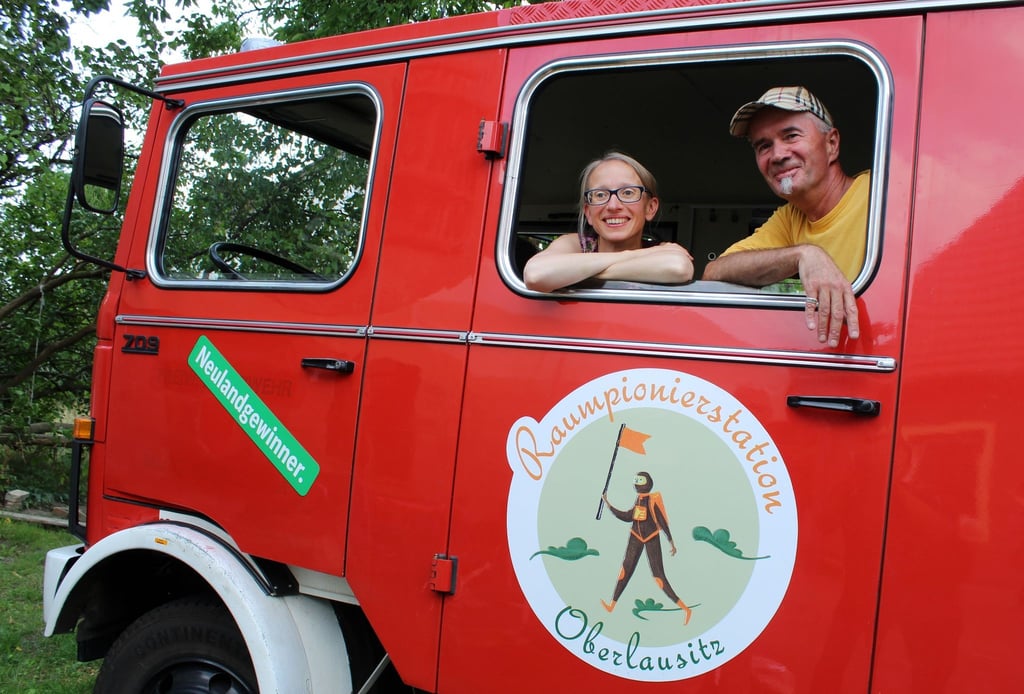 Jan Hufenbach und Arielle Kohlschmidt in ihrem Raummobil, einer roten Feuerwehr.
