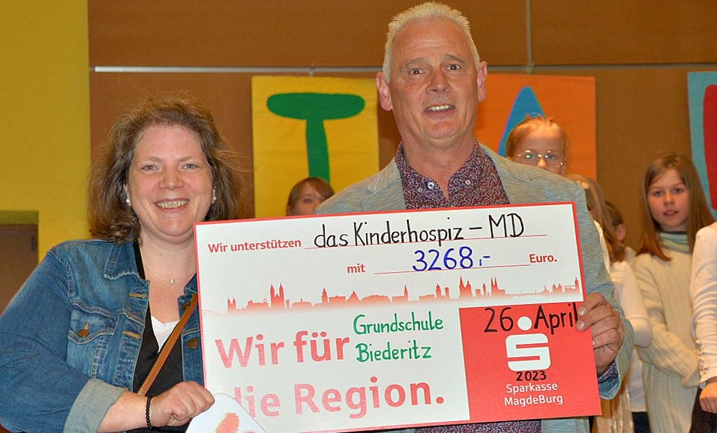Schulleiter Holger Arnold übergibt die Spende an Hanna Klingenberg vom Kinderhospiz Magdeburg .