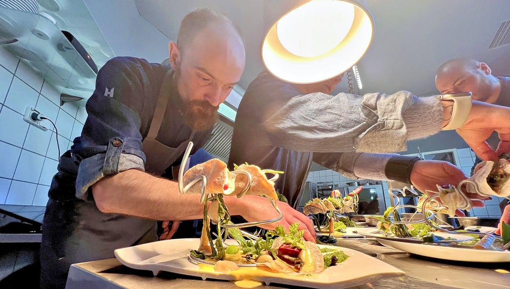 Bei Hardrockmusik herrscht Hektik in der Küche. Sous Chef Paul Thiele richtet mit dem Team die Vorspeise an.
