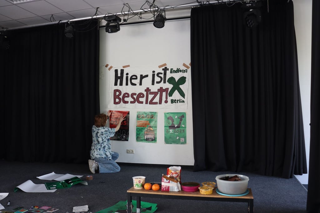 Eine Schülerin hängt ein Plakat an eine Wand des Berliner Melanchthon-Gymnasiums.