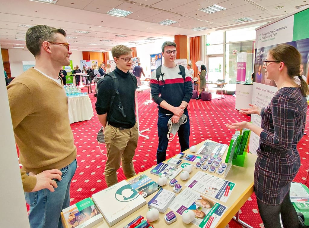 Sebastian Gysi (l.), leitender Oberarzt der Geriatrie im Paul Gerhardt Stift, und Josefine Freitag, Assistenzärztin in der Klinik für Gynäkologie und Geburtshilfe, mit zwei Medizinstudenten auf der Messe „doctors future“