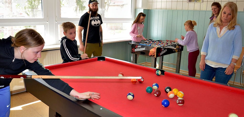 Coline und Luca-Maxim spielen am liebsten Billard, Amy (hinten links) und Kim Kicker. Bereichsleiterin Karin Weinreich (rechts) weiß mit Sylvana Dittmann und Stefan Fiebrandt zwei beliebte pädagogische Fachkräfte im neuen Güstener Treffpunkt. Und mit Diana Sims auch eine gute Küchenfee.
