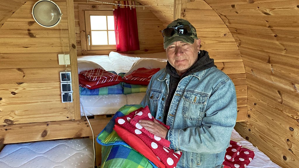 Campingplatz-Betreiber Michael Bathge in einem der Campingfässer, die mit Betten ausgestattet sind.