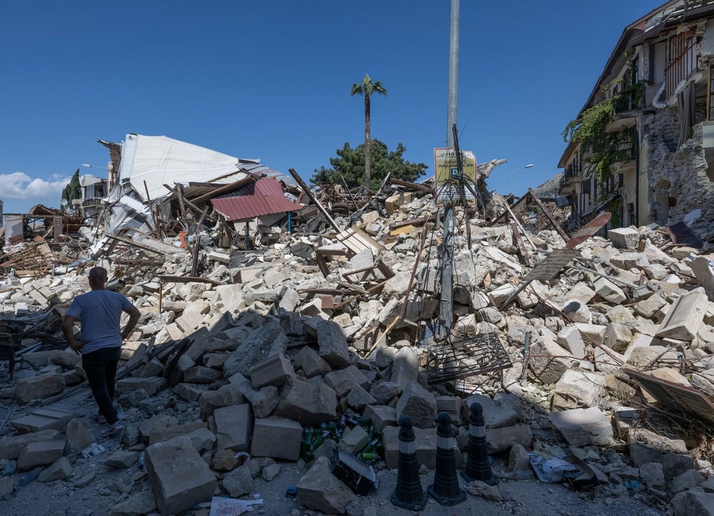 Ein Mann geht in der Altstadt von Antakya an den Trümmern eingestürzter Wohnhäuser durch das Erdbeben vorbei.