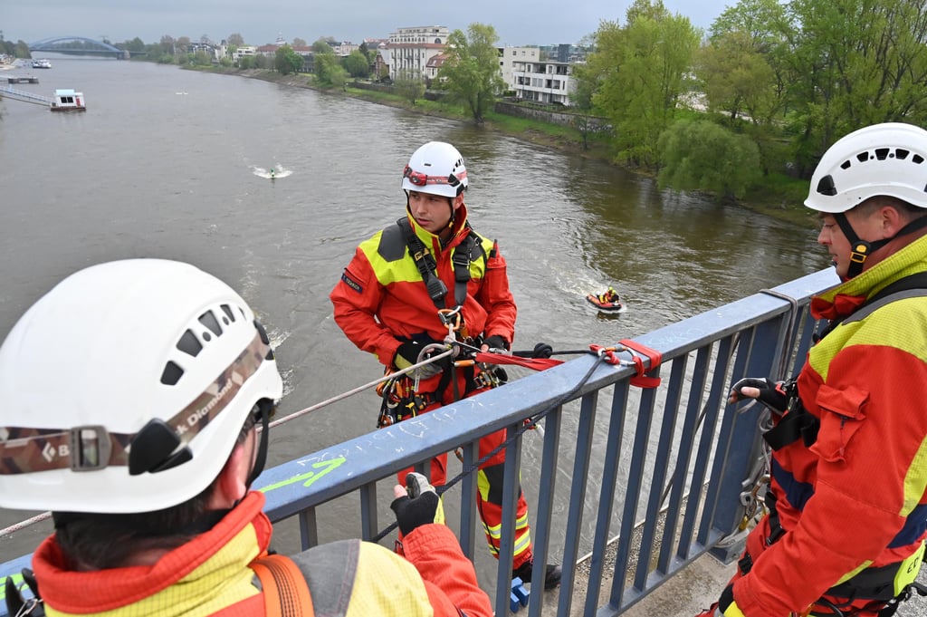 Die Kräfte der Magdeburger Höhenrettung machen sich bereit, den Mann, der am Seil über dem Wasser hängt, zu retten.