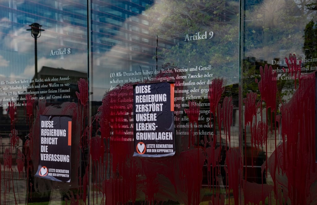 Plakate kleben auf dem beschmierten Denkmal "Grundgesetz 49".
