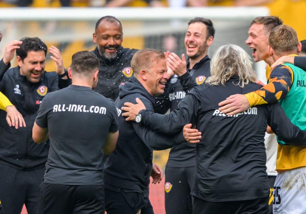 Dynamo Trainer Markus Anfang (M) jubelt nach dem Sieg mit seinen Assistenten und Spielern.