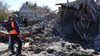 Menschen betrachten ein Gebäude in Saporischschja, dass nach ukrainischen Angaben durch russischen Beschuss zerstört wurde.