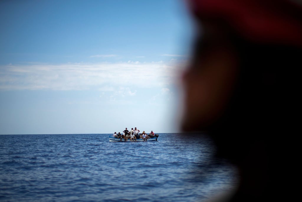 Migranten in einem Holzboot auf dem Mittelmeer. Symbolfoto