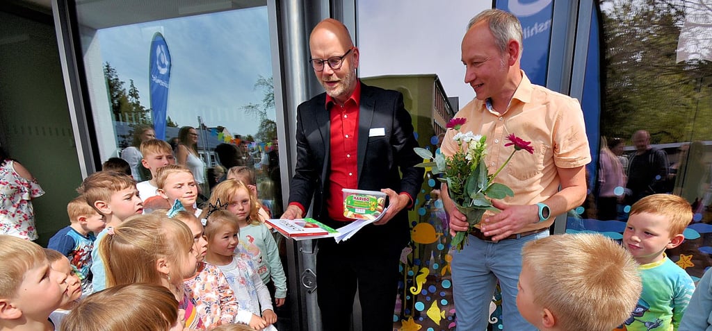 Lebenshilfe-Geschäftsführer Stefan Labudde (Mitte) und der pädagogische Leiter, Nick Mostaller, hatten für die Kinder zur Eröffnung etwas zum Naschen mitgebracht.