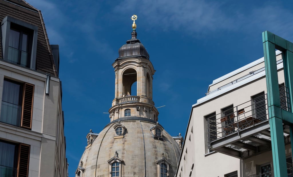 Besucher stehen auf der Aussichtsplattform der Dresdner Frauenkirche oberhalb der sogenannten Steinernen Glocke.