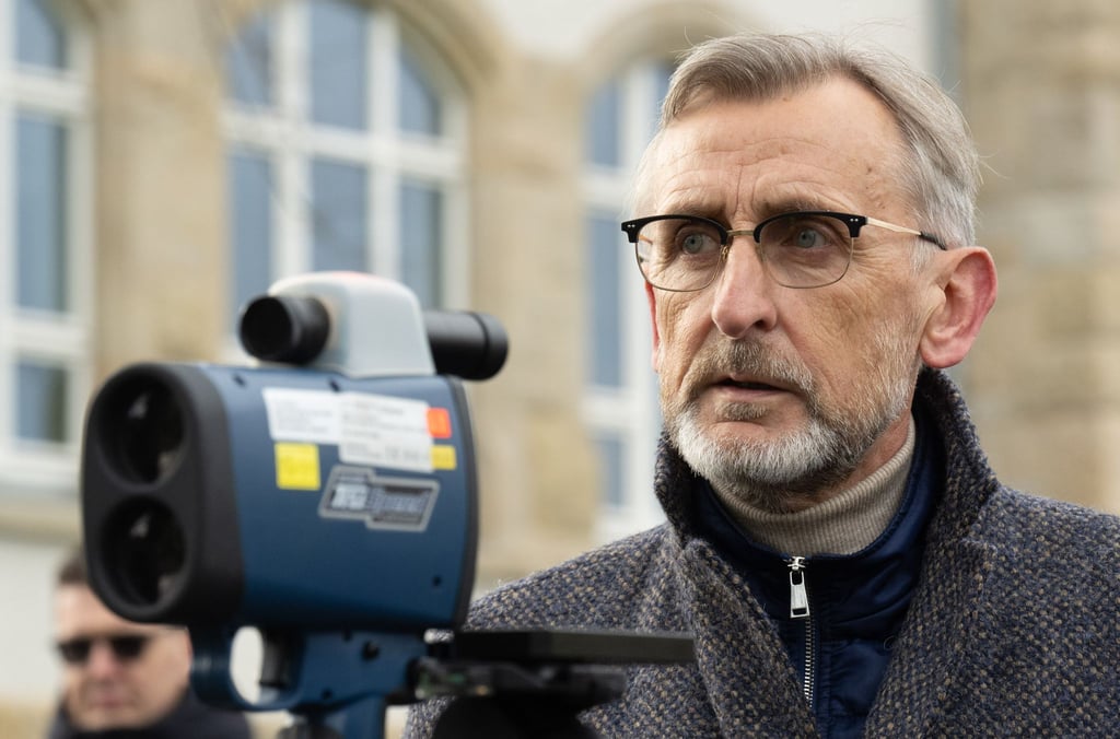 Armin Schuster (CDU), Innenminister von Sachsen steht neben einem Lasermessgerät.