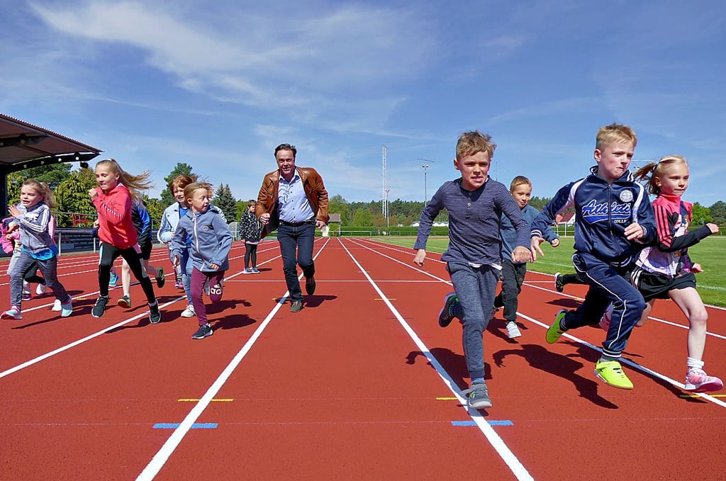 Erstklässler der Grundschule „Max Lingner“ weihen mit Bürgermeister Michael Jahn (SPD) die sanierteTartanbahn in der Jahnsportanlage ein.