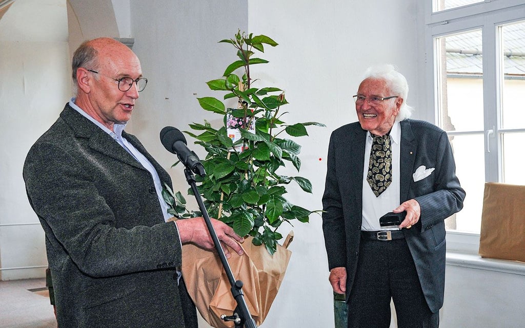 Der Wallhäuser Bürgermeister Dieter Gremmer (links) überreicht Helmut Meier-Föllmi eine Rose.