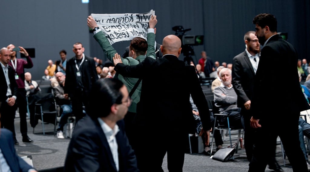 Aktivisten werden bei der Hauptversammlung der Volkswagen AG aus dem Saal geführt.
