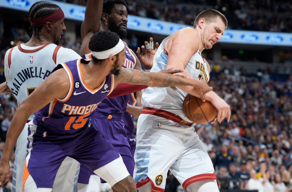 Denvers Nikola Jokic (r) verteidigt den Ball gegen Cameron Payne von den Phoenix Suns.