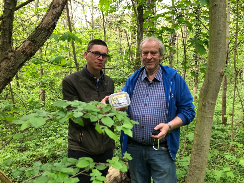 Die Geocacher Michael Kraft (l.) und Klaus Günther finden einen "Schatz" in einer Baumwurzel in den Weißenfelser Badanlagen
