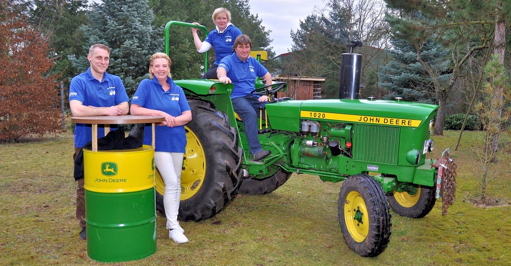 Beatrice und Sven Grütter auf dem familieneigenen John Deere, Dominic Grütter und Bettina Wolle davor.