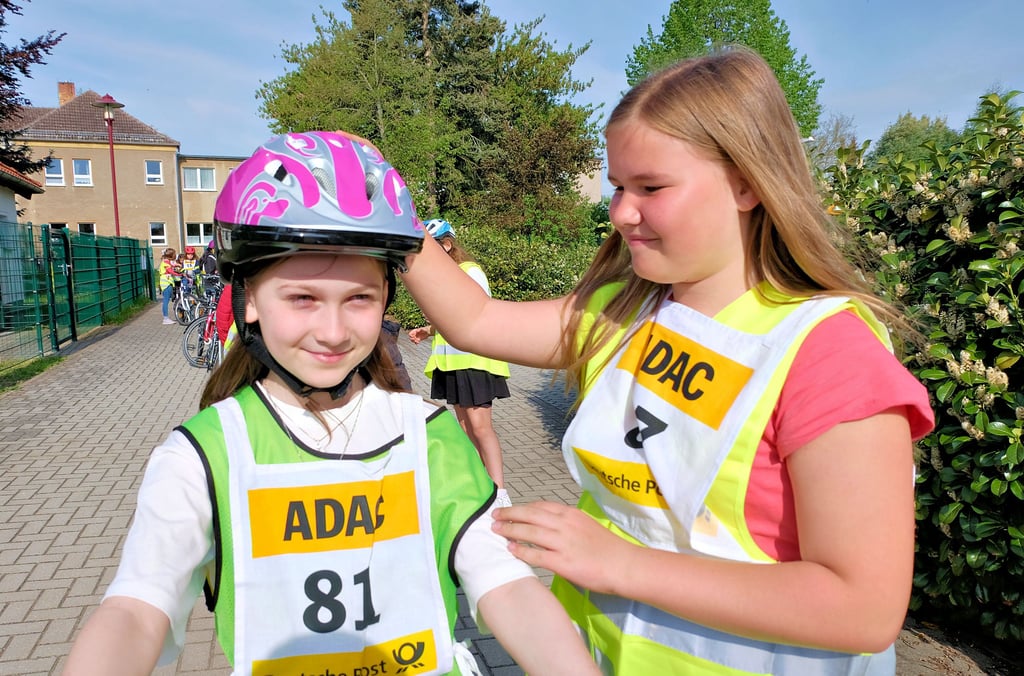 Nette Geste: Adele Klein (rechts) hilft Josefine Helm im Startbereich beim richtigen Aufsetzen des Fahrradhelms.