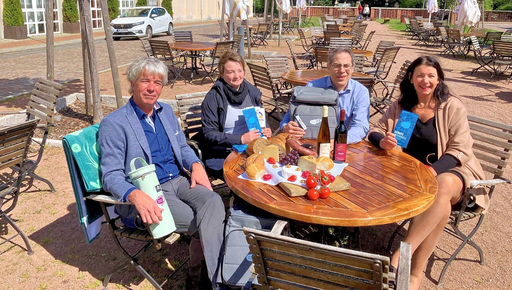 Ralf-Peter Weber, Mandy Moik, Frank Richter und Christine Klauder (v.l.n.r.) bei der Vorstellung der diesjährigen Picknicksafari: Vor dem Hotel „Landhaus Wörlitzer Hof“ gab eine kleine Tafel einen optischen Vorgeschmack auf das, was kulinarisch geboten werden soll.