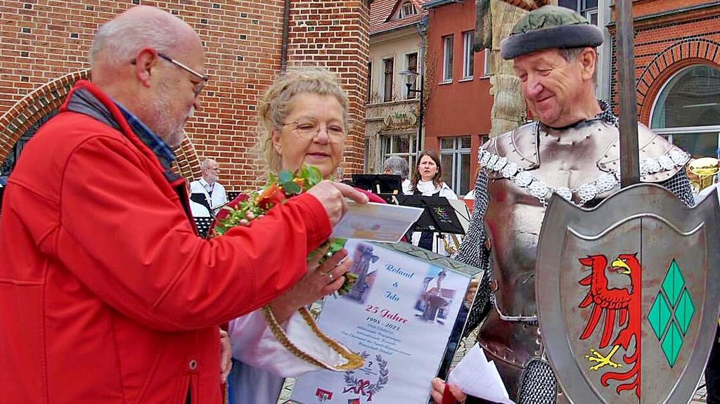 Zur Eröffnung der Stendaler Kulturnacht 2023: Präsident Uwe Trapp vom Ensemble ,,Vier Jahreszeiten" (links) ehrte Roland und seine Ida, alias Andreas und Elke Meßing, zum 25. jubiläum.