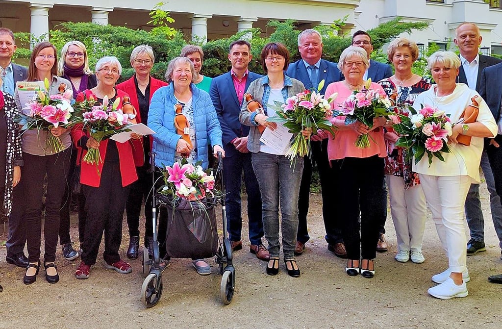 Die neuen Salzlandfrauen erfreuen sich ihres Ehrentitels, ihrer individuell angefertigten Statuen und ihrer Blumensträuße im Kurpark Bad Salzelmen.