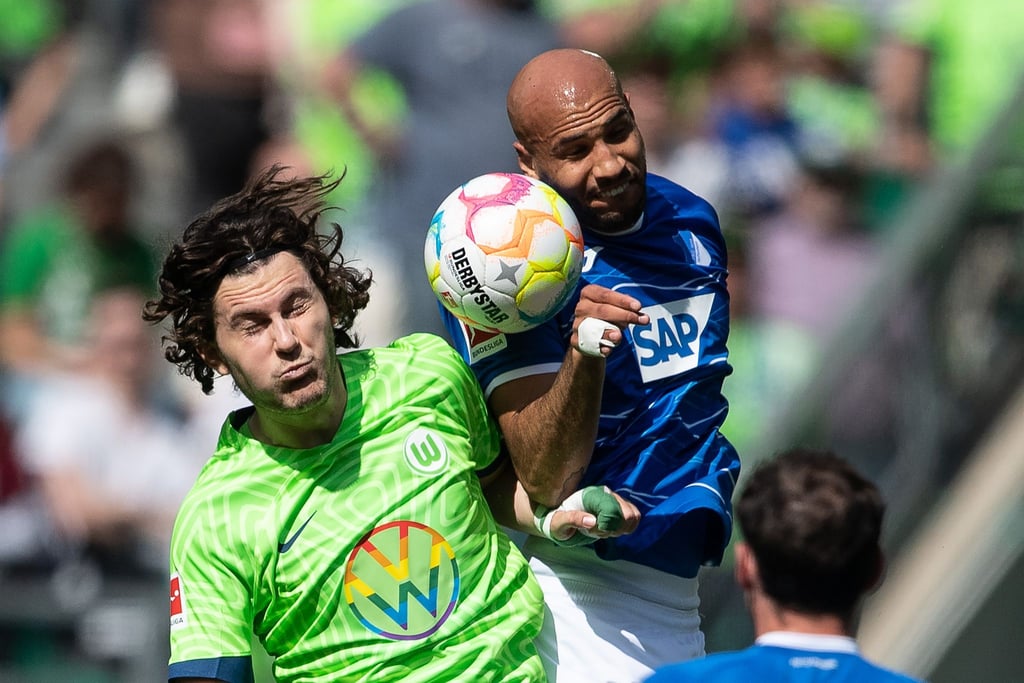 Wolfsburgs Jonas Wind (l) und John Anthony Brooks von der TSG 1899 Hoffenheim kämpfen um den Ball.