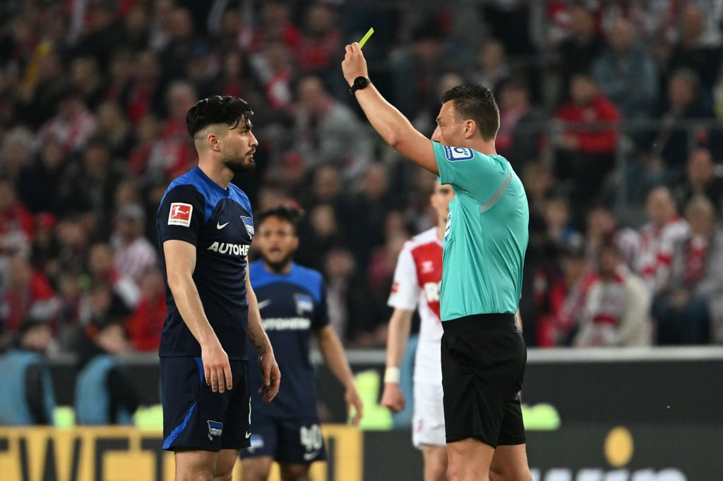 Schiedsrichter Sven Jablonski (r) zeigt Herthas Suat Serdar die Gelbe Karte.