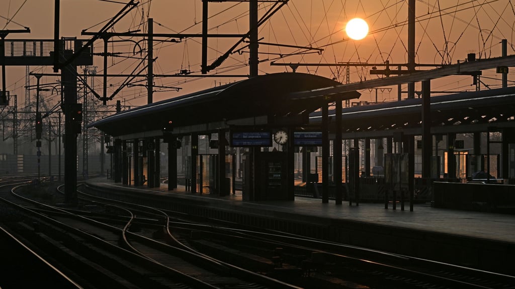 Die Sonne geht über leeren Bahnsteigen am Erfurter Hauptbahnhof auf.