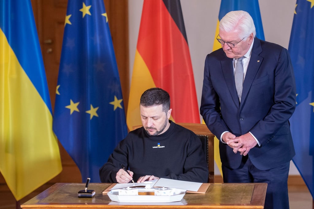 Wolodymyr Selenskyj, Präsident der Ukraine, trägt sich vor seinem Gespräch mit Bundespräsident Frank-Walter Steinmeier (r) in das Gästebuch im Schloss Bellevue ein.