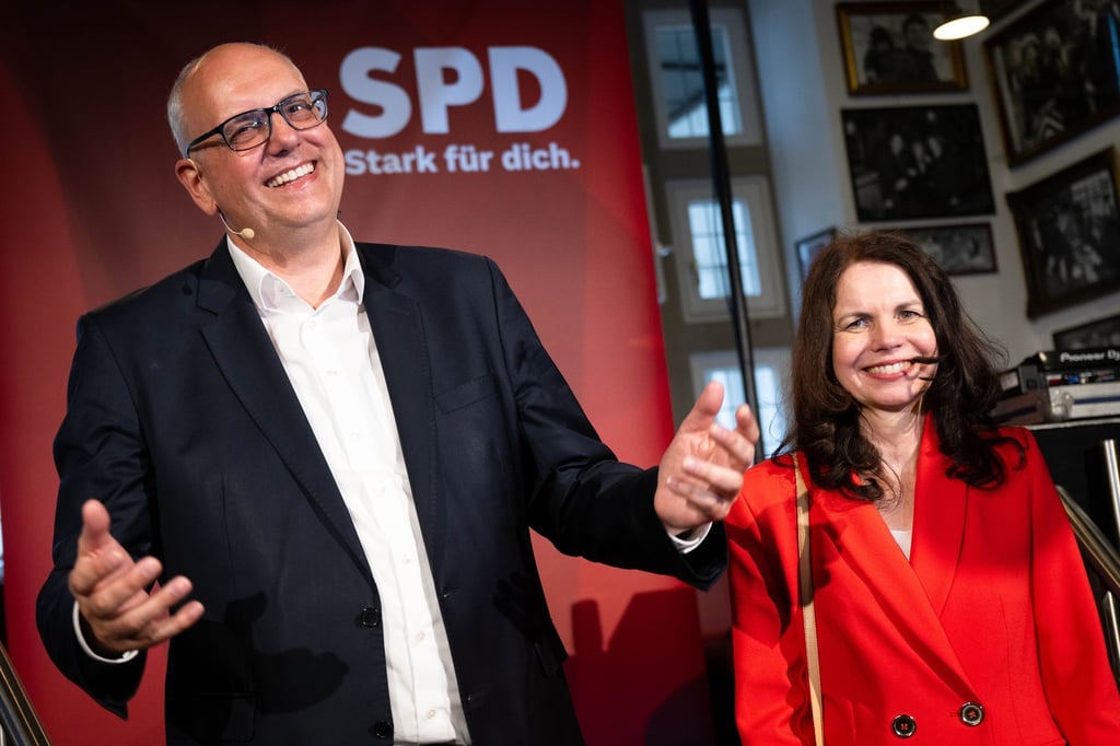 Andreas Bovenschulte, Spitzenkandidat der SPD in Bremen, und seine Partnerin Kerstin Krüger stehen nach Bekanntgabe der ersten Prognose für die Wahl zur Bremischen Bürgerschaft auf der Bühne der SPD-Wahlparty.