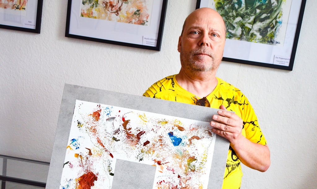 Thomas Dietrich zeigt eine von ihm mit einem Bügeleisen bemalte Fliese, die Teil der Ausstellung im Museum des Heimatvereins Teuchern ist.