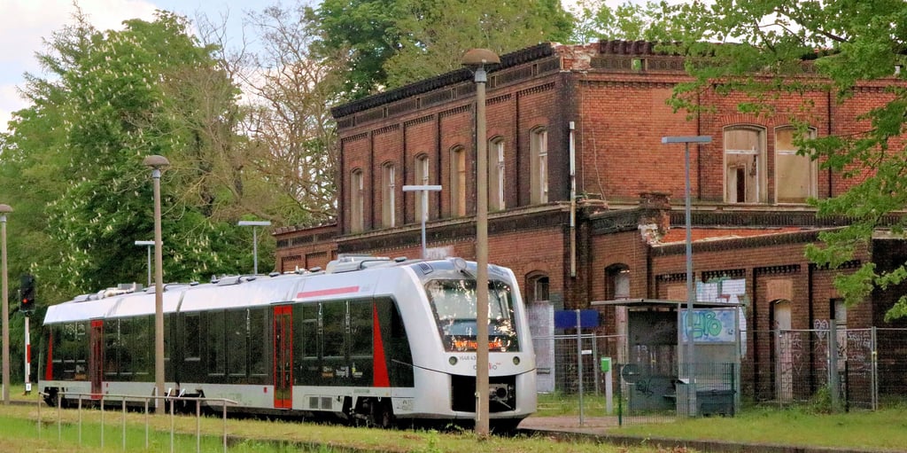 Hier hält der Zug am Bahnhof Calbe West vor einer Ruine. Seit langer Zeit steht bereits ein Bauzaun rund um das ehemals prächtige Bahnhofsgebäude. Einladend wirkt der Bahnhof daher auf die Bürger nicht.