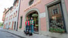 Seppi Küblbeck (r) und Oliver Storz mit ihren drei Dackeln: Wegen eines Streits mit der Passauer Stadtverwaltung ist sind sie mit ihrem Dackelmuseum nun nach Regensburg umgezogen.
