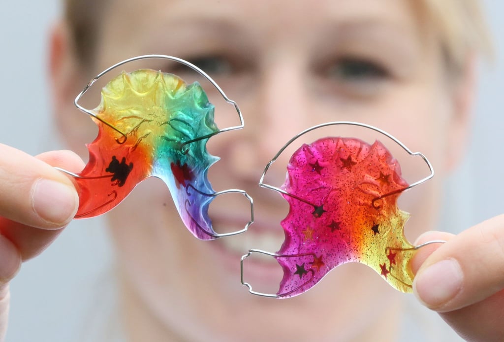Ein Zahnspangen-Modell in lustigen Regenbogenfarben kann hilfreich sein, damit kleine Träger überhaupt Lust bekommen, das Hilfsmittel auch auszuprobieren.