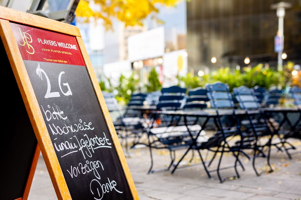 Ein Aufsteller auf der Terrasse eines Restaurants weist auf die 2G-Regel hin.