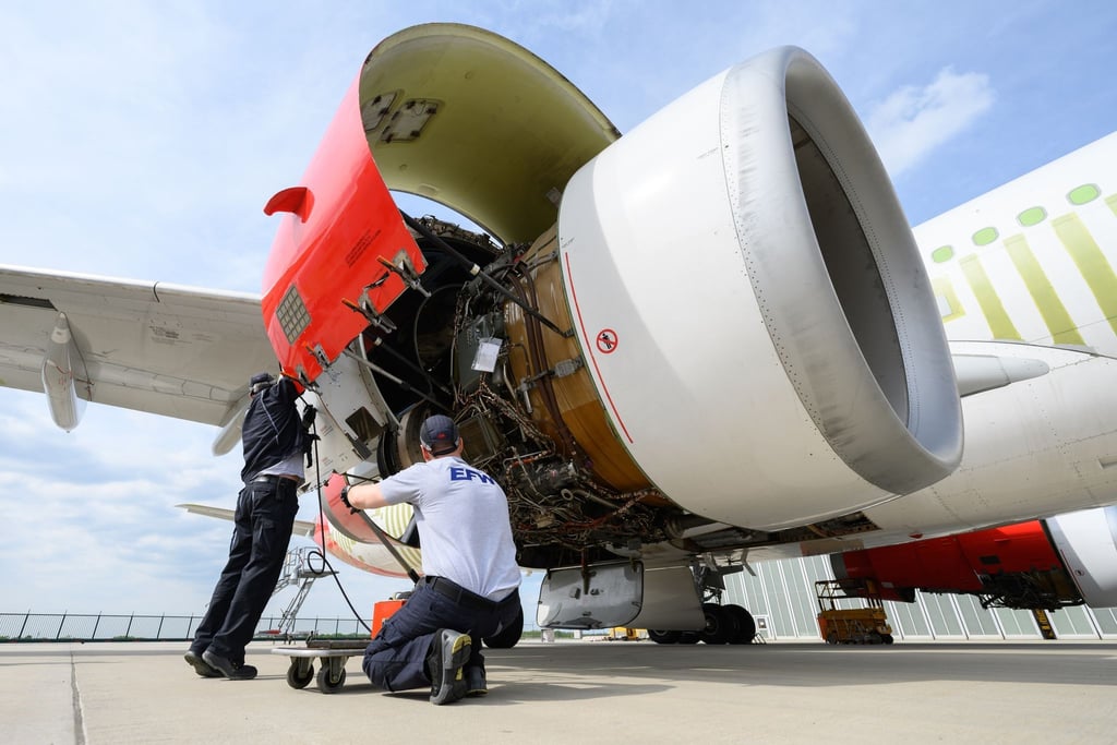 Mitarbeiter der EFW Elbe Flugzeugwerke GmbH arbeiten am Triebwerk eines Airbus A330.