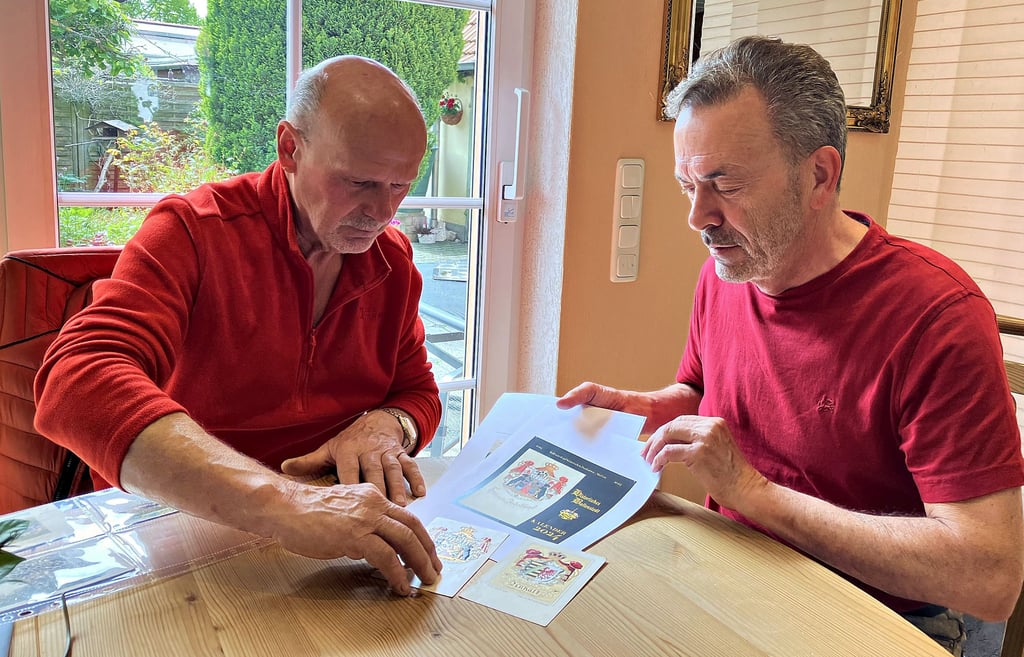 Herbert Dzienkowski (links) und Klaus Gebhardt vergleichen Original und Druckexemplar von historischen Postkarten.