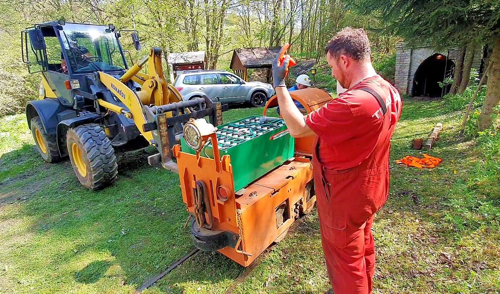 Der Akku wird auf den Unterbau der Lok gesetzt. Sie soll den Mannschaftswagen ziehen, mit dem Besucher am 1. Juli in den Glasebacher Stollen einfahren können.