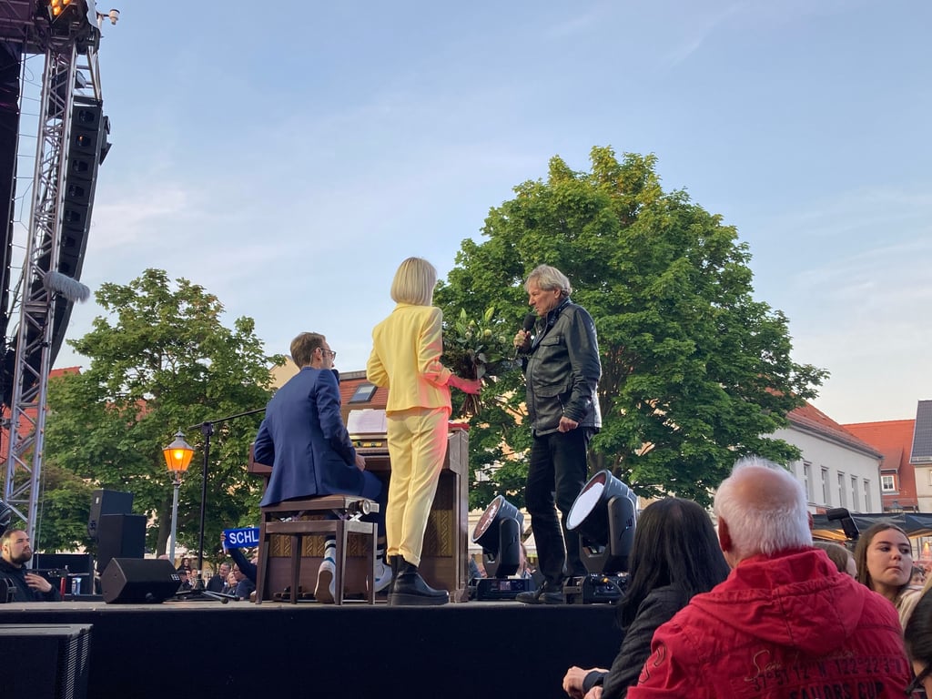 Bernhard Brink (re.) hatte am Mittwoch Geburtstag und stand in Aken auf der Bühne. Moderator Peter Imhof und Moderatorin Christin Stark haben ihm mit einem Ständchen und Blumen gratuliert.