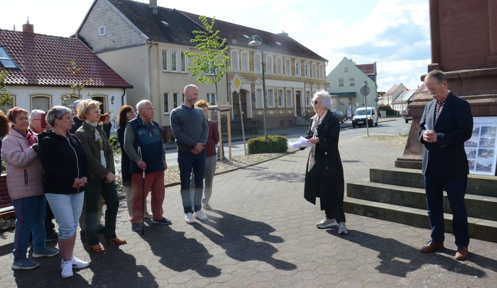 Bärbel Röber (Mitte) liest ein selbstgeschriebenes Gedicht über den Denkmalplatz vor.