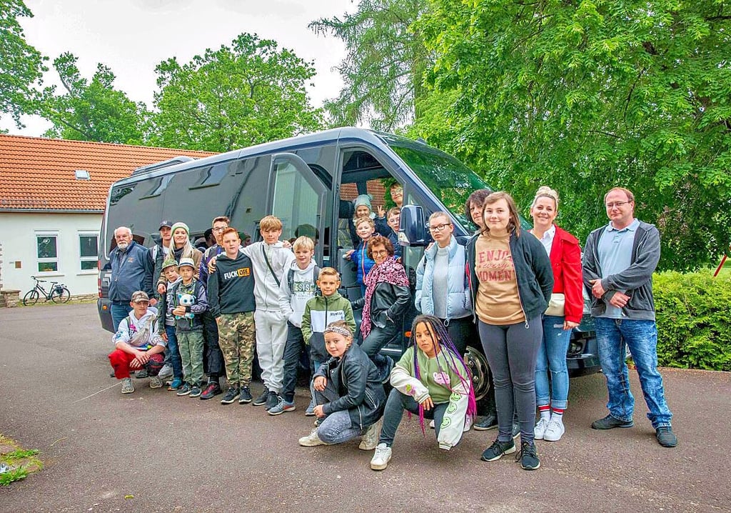 Birgit Vetter, Inhaberin der Vetter Bustouristik (Bildmitte an der Fahrertür) unterstützt eine Freizeitfahrt der Heimkinder zum Belantis Freizeitpark.
