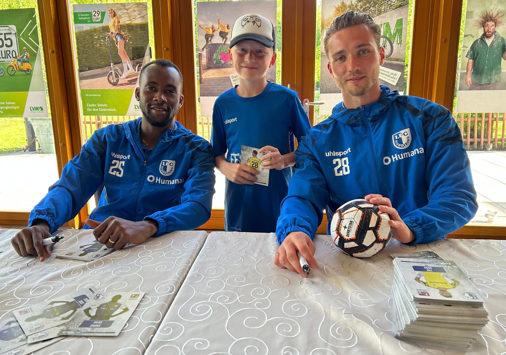 FCM-Spieler SIlas Gnaka (links) und FCM-Torwart Tim Boss bei ihrer Autogrammstunde in Magdeburg-Olvenstedt. In der Mitte der neunjährige Fan Aiden.