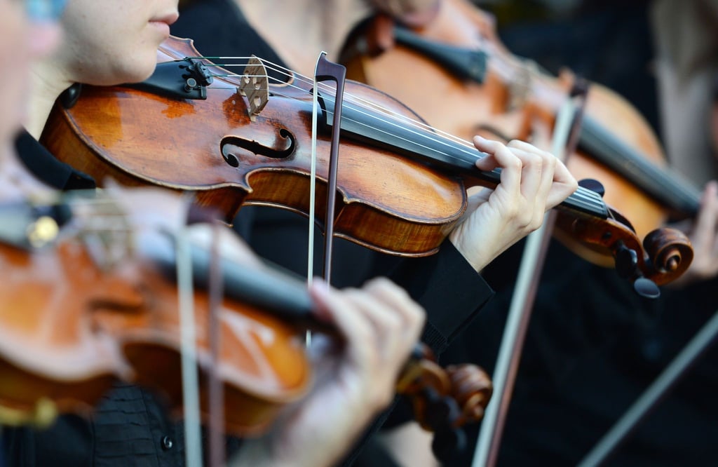 Violinistinnen spielen im Schlosspark in Rheinsberg bei einer Opernaufführung.